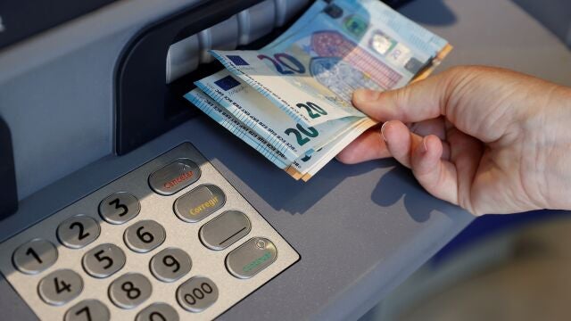 Una persona saca dinero del cajero