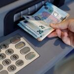 Una persona saca dinero del cajero