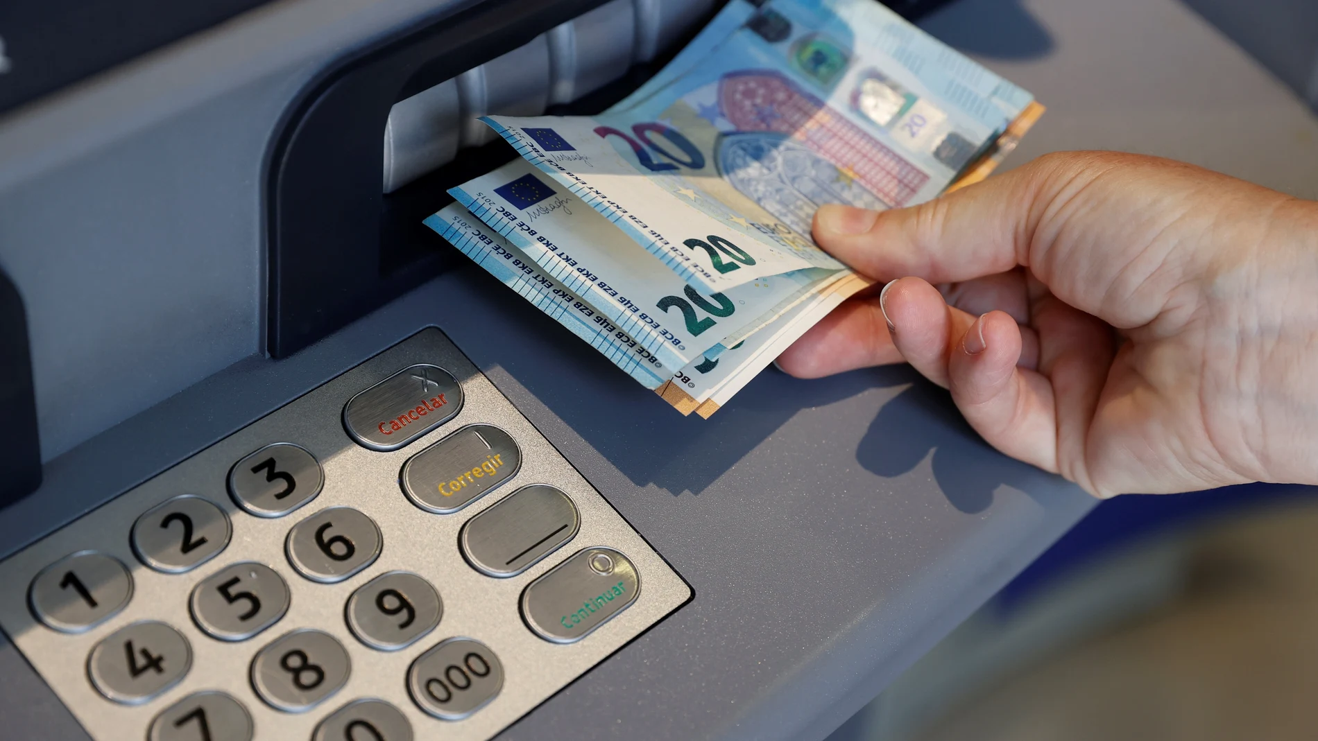 Una persona saca dinero del cajero