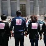 Un grupo de denunciantes protesta ante el Congreso de los Diputados