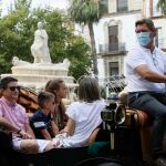 Un coche de caballos con varios turistas en Sevilla