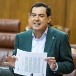 El presidente andaluz, Juanma Moreno, muestra un documento ayer en el Parlamento regional