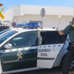 Imagen de un agente y de un vehículo de la Guardia Civil