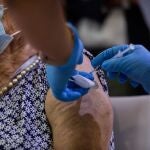 Una sanitaria vacuna a una mujer con la tercera dosis del Covid-19 en Madrid