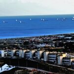 Vista de un rosario de buques que vuelve a Gibraltar, al fondo, desde el municipio gaditano de La Línea