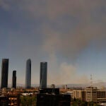 El humo se eleva sobre el fuego que se ha iniciado en una zona de descampado ubicada en la calle Juan Lozano, próxima al hospital de La Paz y a las Cinco Torres, por causas que se desconocen