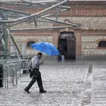 Una persona camina con paraguas bajo una tormenta de verano