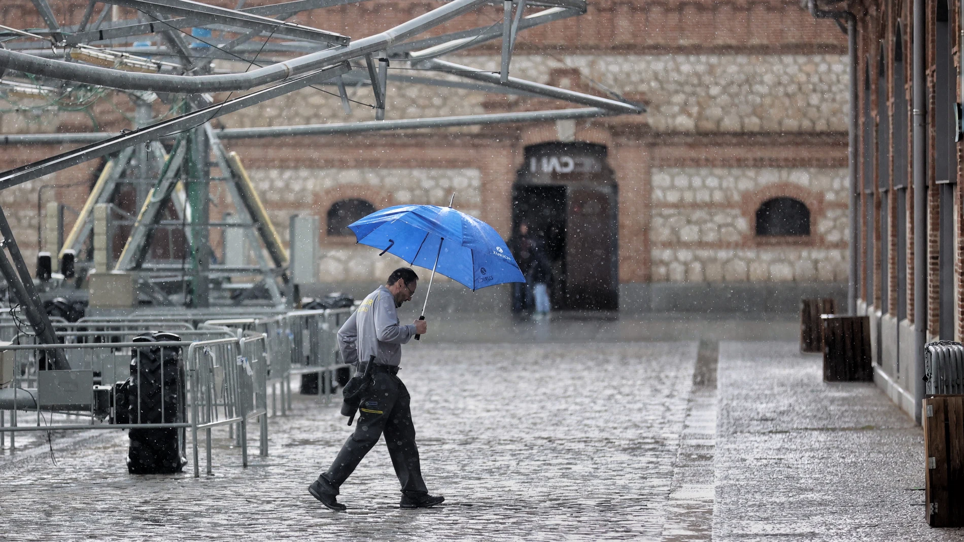 Una persona camina con paraguas bajo una tormenta de verano