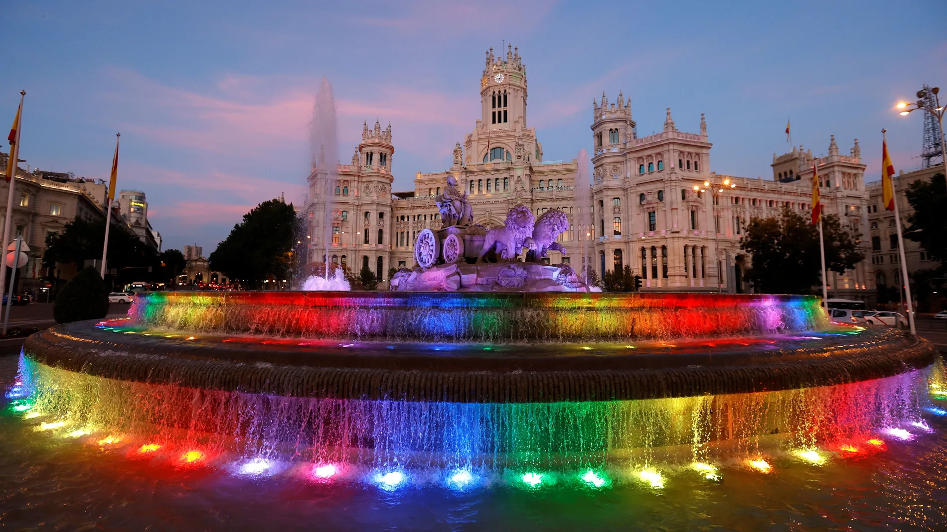 La fuente de Cibeles aparece iluminada con los colores de la bandera LGTBI con motivo del inicio de la fiestas del Orgullo 2021