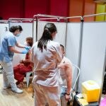 Dos personas reciben una dosis de la vacuna de Pfizer-BioNTech contra el Covid-19 en el Hospital Severo Ochoa de Leganés