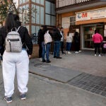 Un grupo de personas esperan en una fila en el Centro de Salud Abrantes, en Madrid