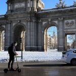 Un hombre circula con su patinete eléctrico por la madrileña calle Alcalá este lunes, tras el paso de la borrasca Filomena