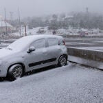 Un coche cubierto de nieve en el Puerto de Navacerrada