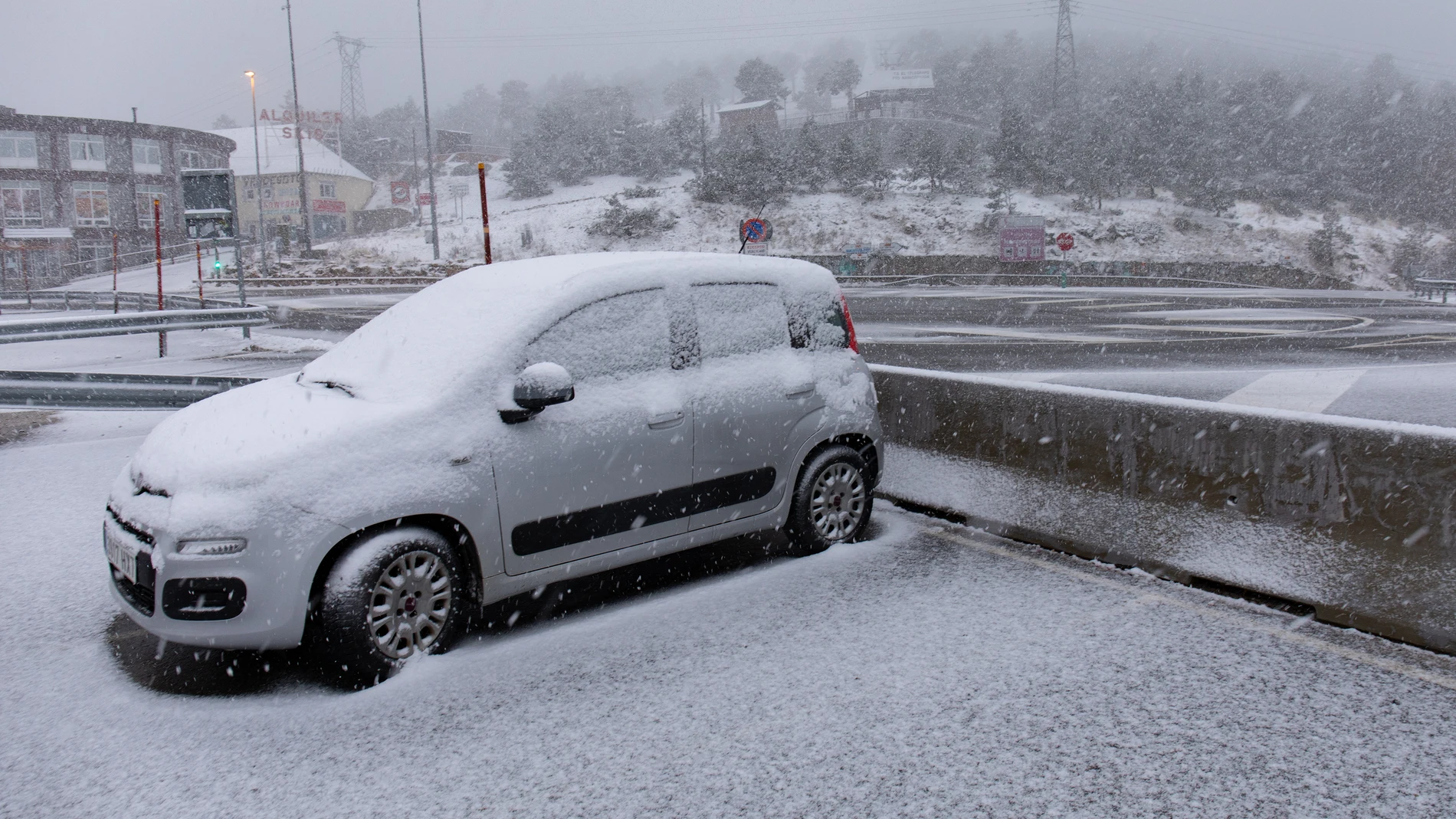 Un coche cubierto de nieve en el Puerto de Navacerrada