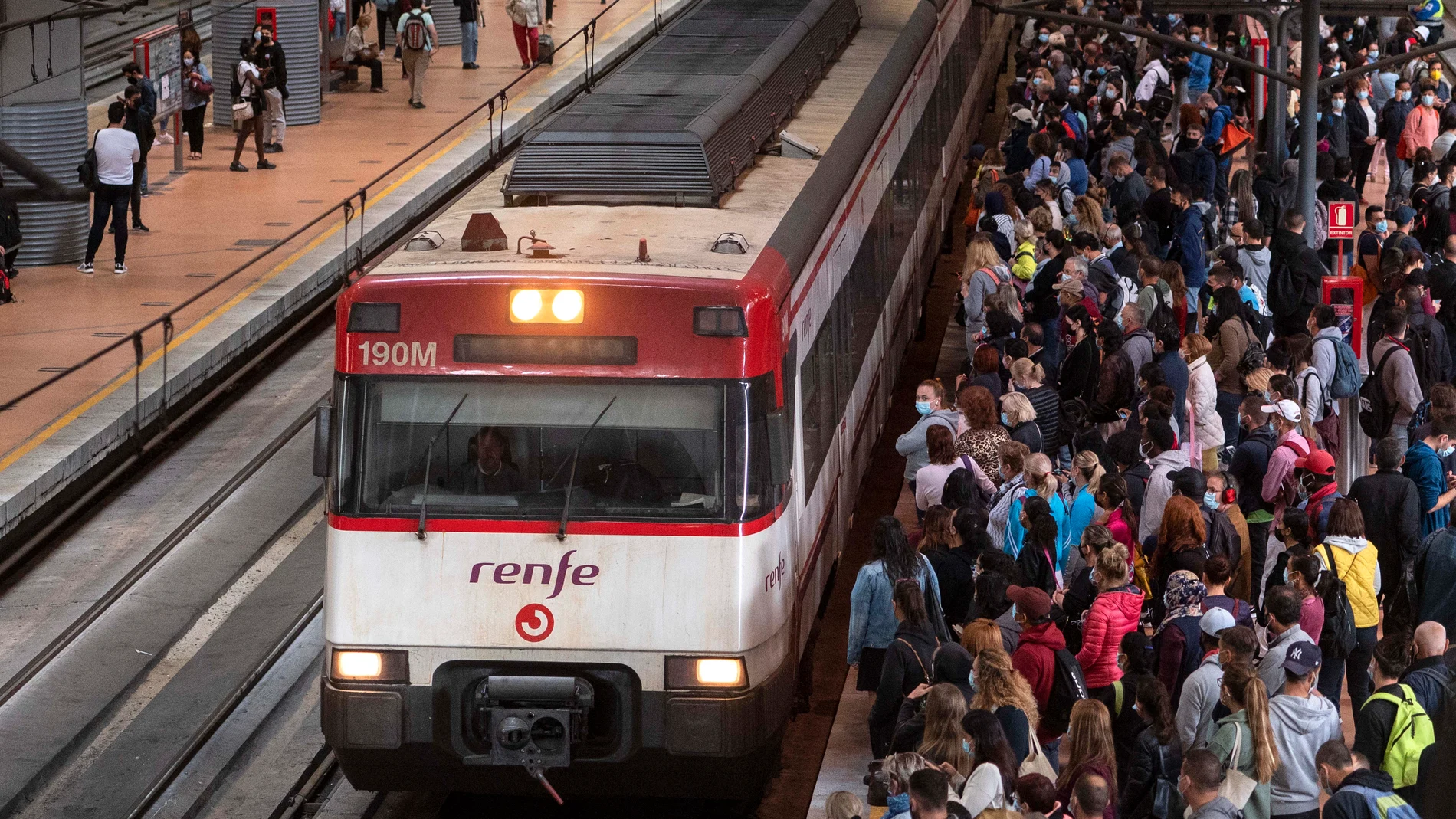 Un gran número de pasajeros espera la llegada de un tren en la estación de Madrid Puerta de Atocha