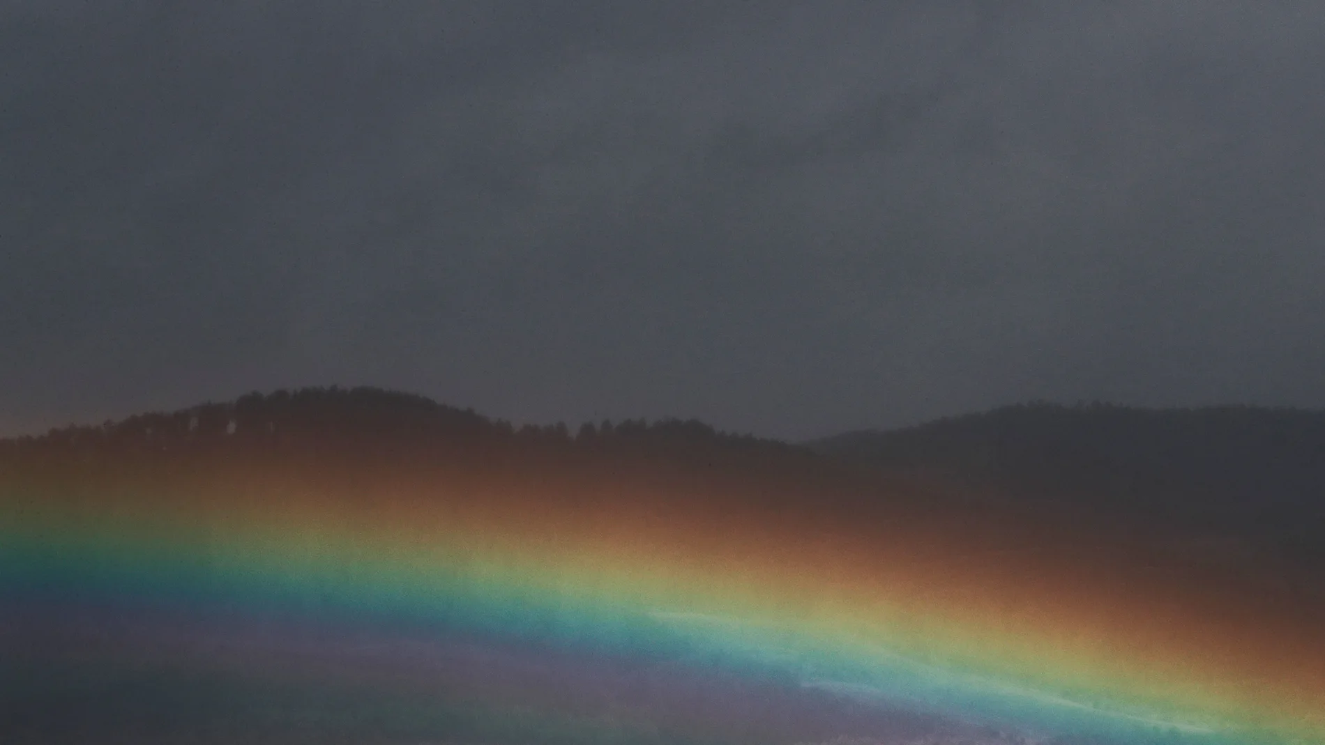 Imagen de archivo de un arcoiris con la lluvia.