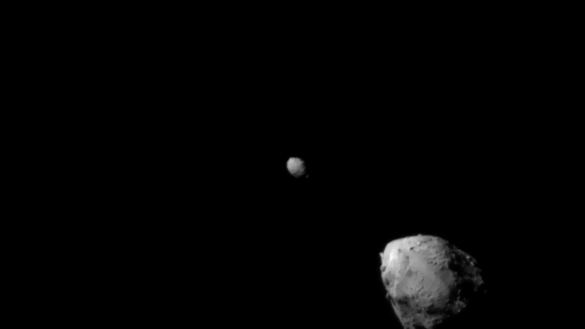 Dos rocas grises, una más grande y otra más pequeña, sobre fondo negro