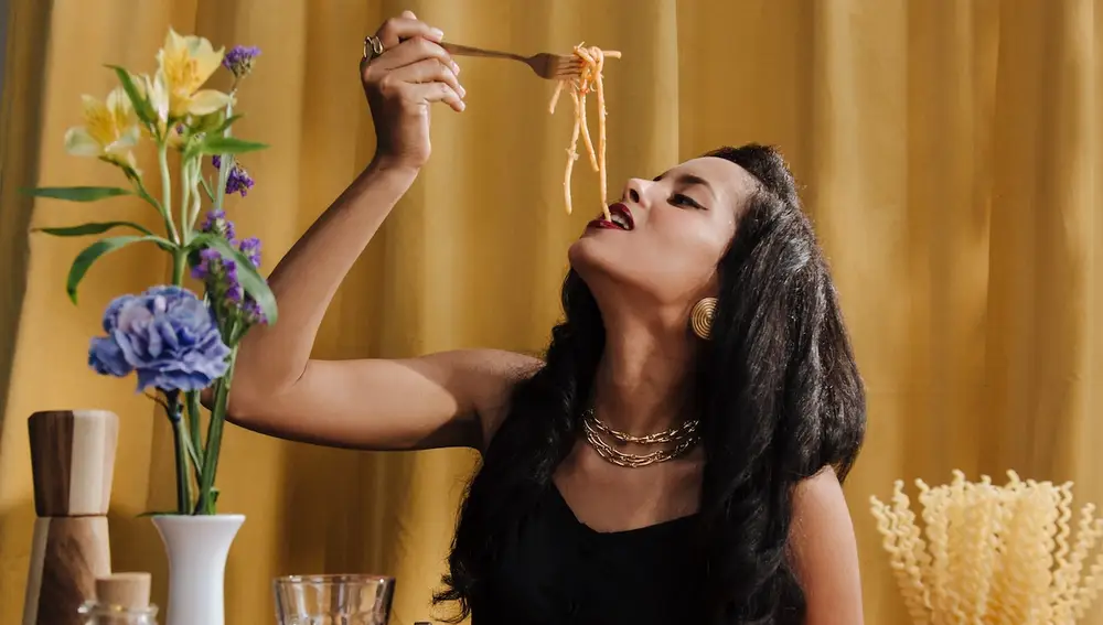 Mujer comiendo y celebrando el día de la pasta