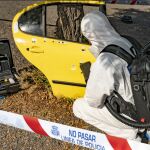 Un agente de policía analiza los impactos de bala en un automóvil