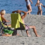 Unas personas disfrutan del buen tiempo en la playa de Aguadulce en Roquetas de Mar (Almería)
