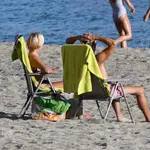 Unas personas disfrutan del buen tiempo en la playa de Aguadulce en Roquetas de Mar (Almería)