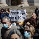Un manifestante sostiene una pancarta durante una concentración convocada por la Unidad de Acción de los Movimientos de Pensionistas, ante el Congreso de los Diputados