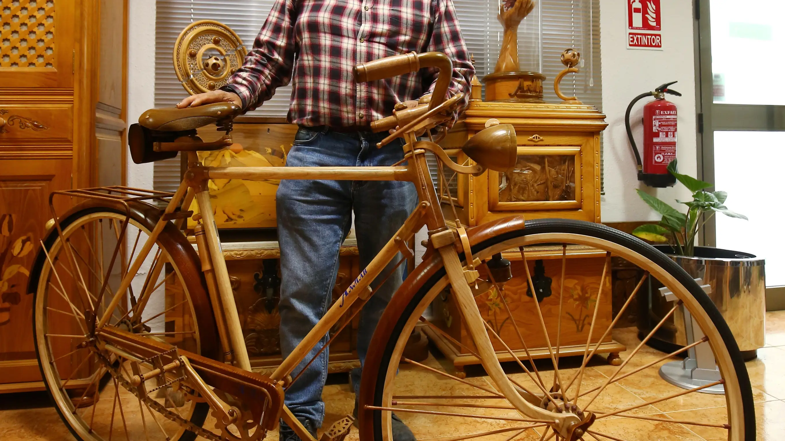 José Pérez, de la empresa de artesanía Anmar de Cabañas Raras (León), junto a la reproducción en madera de la mítica bicicleta BH Gacela