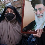 Una mujer muestra una imagen del líder supremo de Irán, Ali Jameneí, durante una manifestación en Teherán