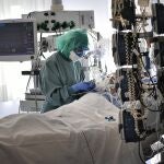 Un sanitario atiende en la UCI a un paciente con Covid