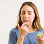 Labios agrietados, mujer poniéndose cacao en los labios | Fuente: Dreasmtime