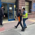 Imagen de uno de los detenidos, custodiado por la Policía Nacional