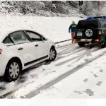 Un vehículo de la Guardia Civil remolca a un coche atrapado en la nieve