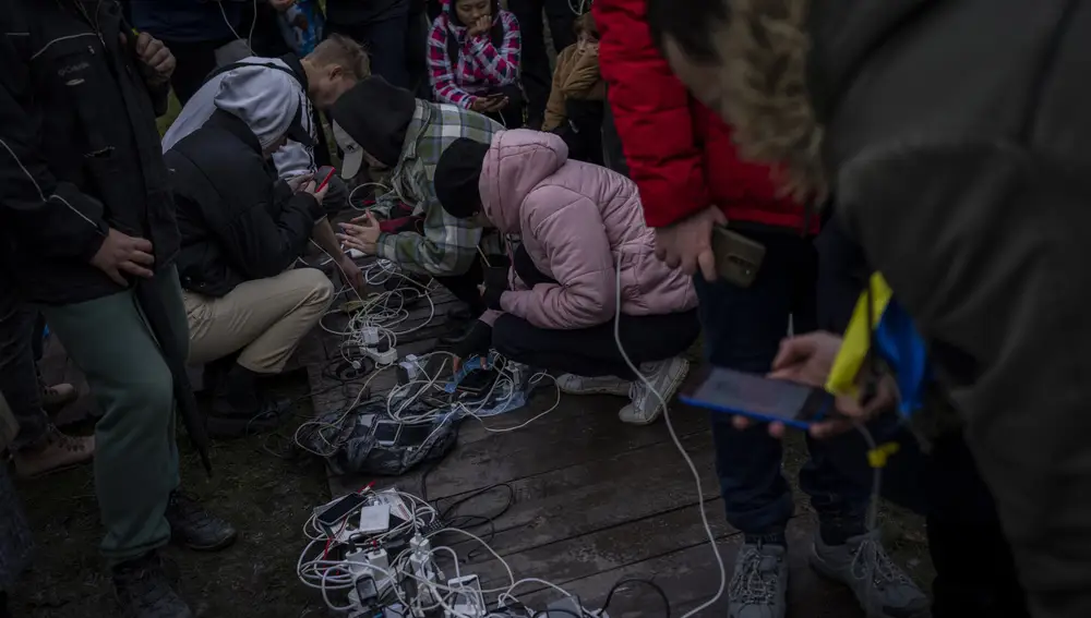 Los residentes enchufan teléfonos móviles y bancos de energía en un punto de carga en el centro de Jersón
