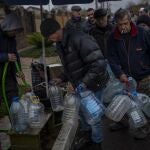 Los residentes llenan contenedores con agua potable en Jersón, este domingo