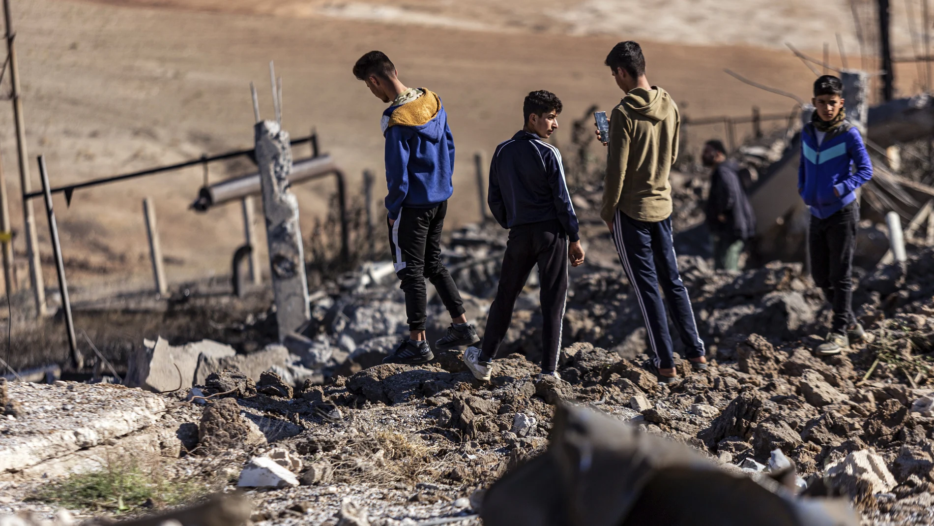 Unas personas inspeccionan un lugar dañado por los ataques aéreos turcos que afectaron a una estación eléctrica en el pueblo de Taql Baql, en la provincia de Hasakeh, Siria