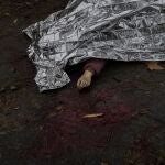 El cuerpo de una mujer muerta durante un ataque ruso es cubierto con una manta de emergencia antes de ser transportado a la morgue en Jersón