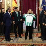 El vicepresidente de la Cámara, Alfonso Rodríguez Gómez de Celis (1i); el presidente del Real Betis Balompié, Ángel Haro (2i); y la presidenta del Congreso, Meritxell Batet con la camiseta del Real Betis Balompié