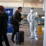 Personal del aeropuerto de Pekín pide a los pasajeros su declaración de salud para poder abandonar la capital china