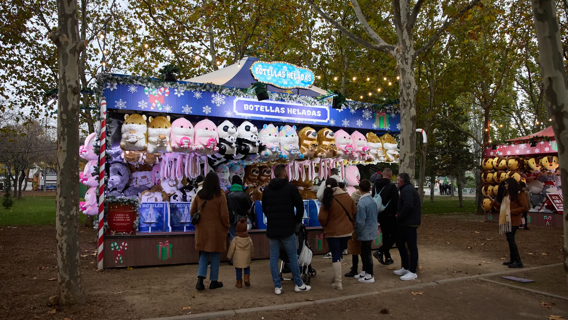 Una familia disfruta de uno de los puestos del Parque Mágicas Navidades en Torrejón de Ardoz (Madrid)