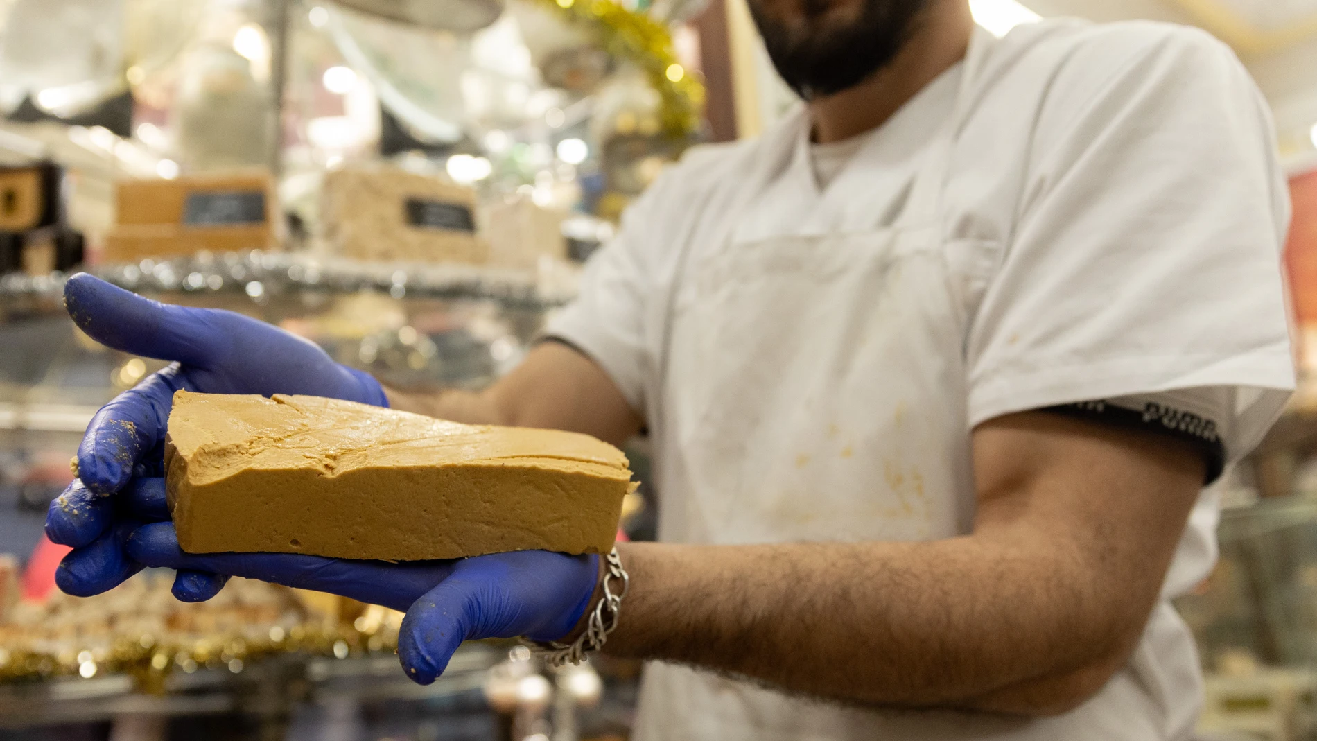 Un pastelero muestra un bloque de turrón en la tienda de turrones Casa Mira, a 5 de diciembre de 2022, en Madrid (España)