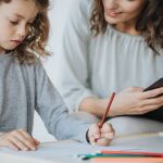 Niño con trastorno del espectro del autismo en compañía de un adulto
