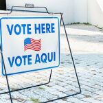 Cartel bilingüe informa sobre centros de votación