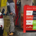 Una persona echa gasolina del surtidor de una gasolinera