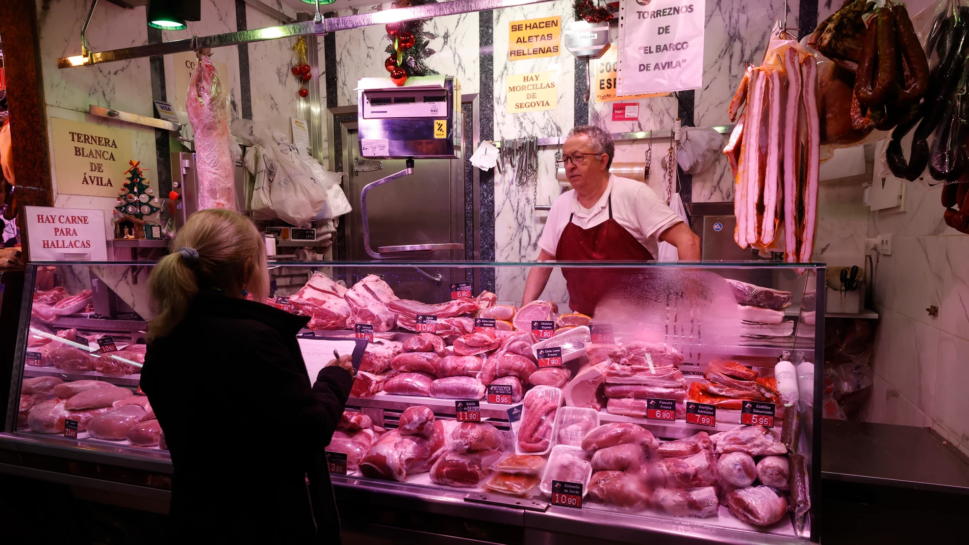 Una técnico del INE, apunta los precios de la carne en un mercado de Madrid