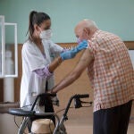 Una enfermera vacuna a un hombre contra la gripe y la covid