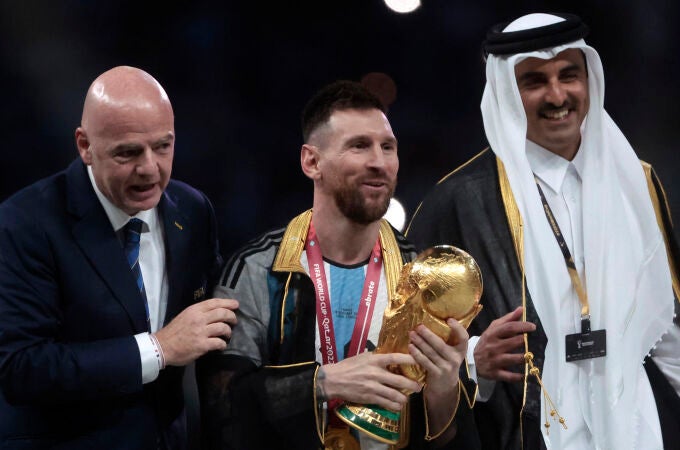 Messi, con el trofeo de la Copa del Mundo junto a el presidente de la FIFA y el Emir de Qatar