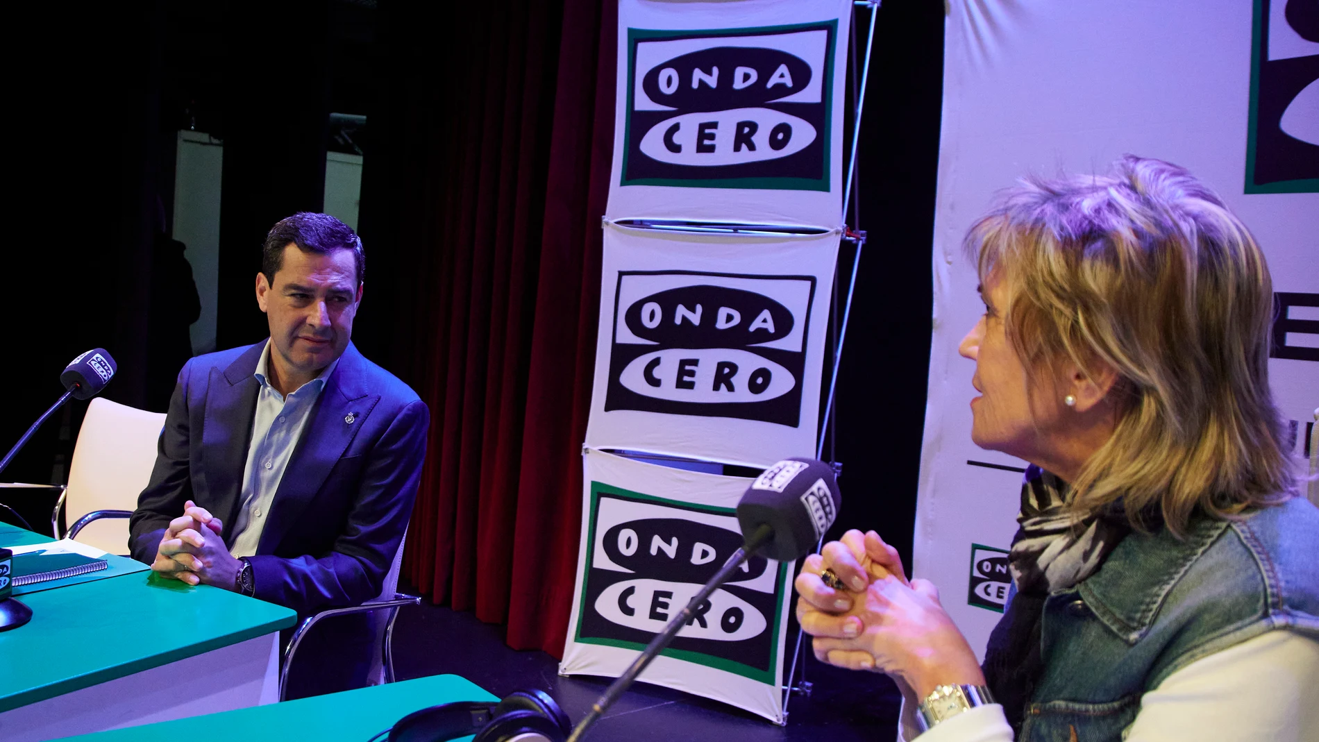 El presidente de la Junta de Andalucía, Juanma Moreno, (i) dialoga con la periodista Julia Otero (d) durante el programa ‘Julia en la Onda’ de Onda Cero en la Fundación Cajasol, a 20 de diciembre de 2022 en Sevilla