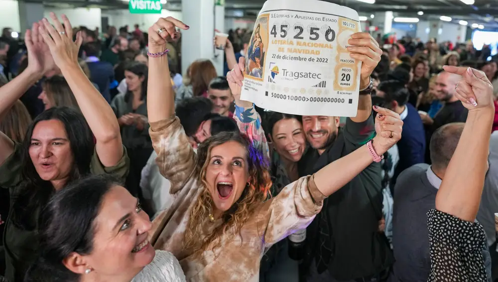 Empleados de la empresa Tragsatec celebran en sus oficinas, situadas en en el polígono industrial de Julián Camarillo, en el distrito de San Blas de Madrid, después de que el número que llevaban, el 45250, haya sido agraciado con el tercer premio de la Lotería de Navidad 2022