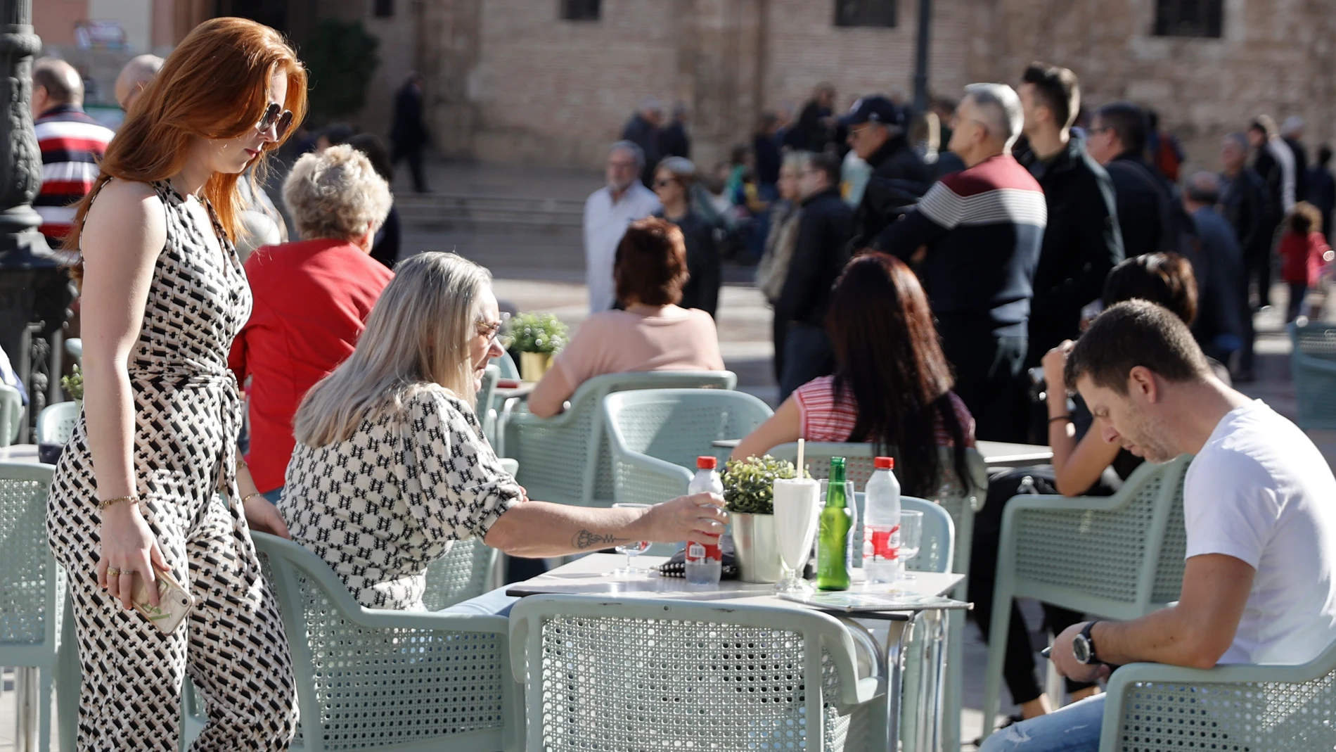Varios turistas disfrutan del tiempo primaveral en una terraza del centro de la ciudad
