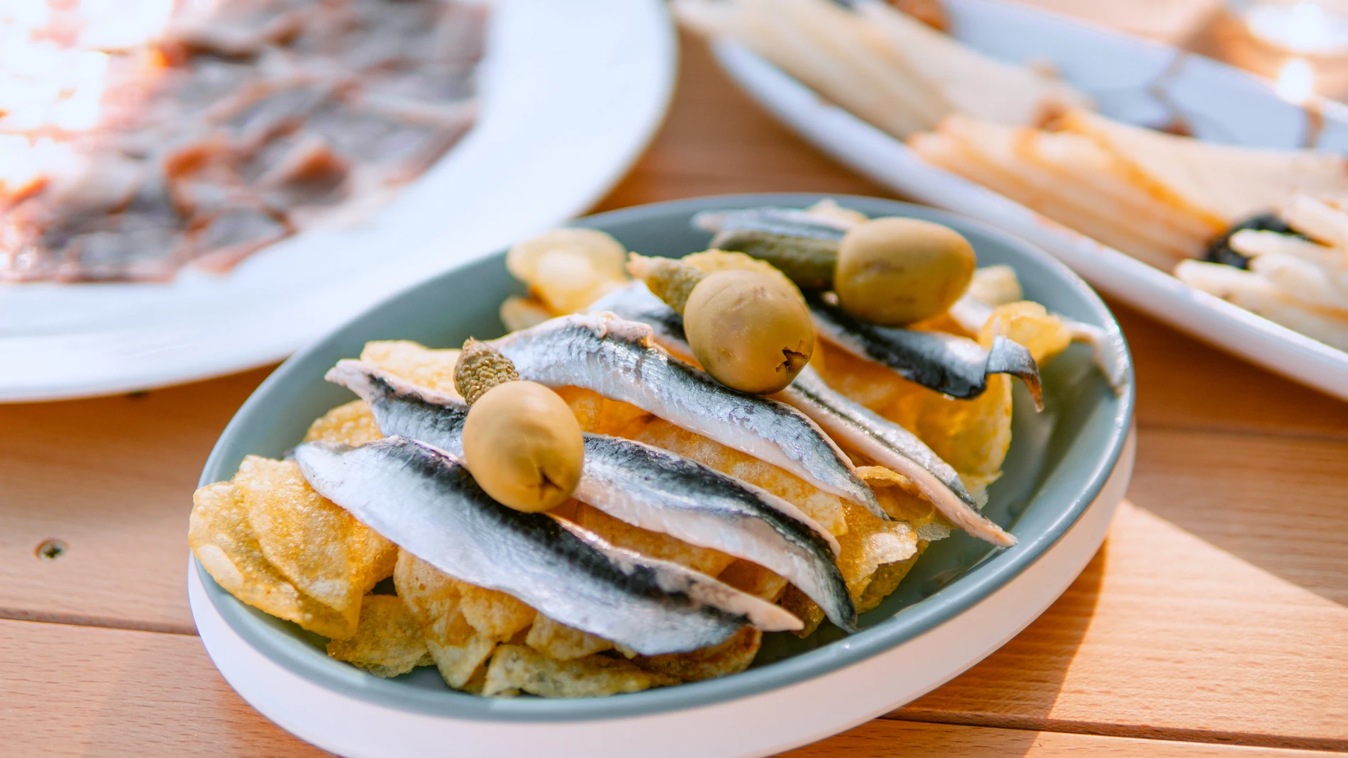 Boquerones en vinagre, patatas chips hispalana y aceitunas